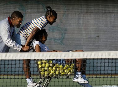 Photo extraite du film , représentant la famille Williams (le père et ses deux filles) pendant un entraînement de tennis dans leur ville natale