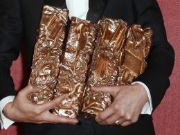 photo d'un homme portant des statuettes Césars