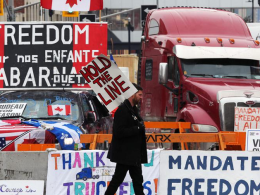 Des militants canadiens anti pass sanitaire et pass vaccinal bloquent la capitale canadienne d’Ottawa, en bloquant les routes avec des véhicules et en militant avec des banderoles (crédit photo : AFP)