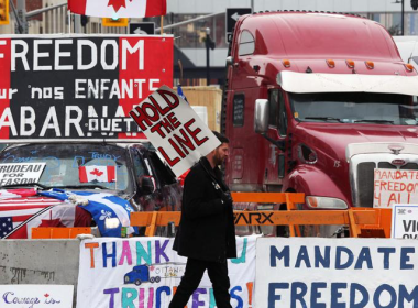 Des militants canadiens anti pass sanitaire et pass vaccinal bloquent la capitale canadienne d’Ottawa, en bloquant les routes avec des véhicules et en militant avec des banderoles (crédit photo : AFP)