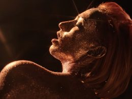 Suzane brillant dans le noir, la peau recouverte de paillettes dorées