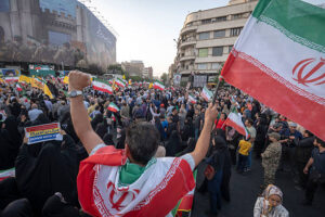 Un Iranien avec le drapeau national célèbre le cessez-le-feu après 12 jours de guerre à Téhéran, le 24 juin 2025. (Photo de Morteza Nikoubazl/NurPhoto via Getty Images)