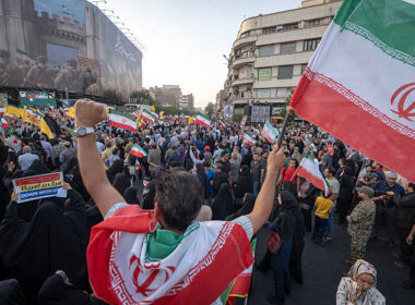 Un Iranien avec le drapeau national célèbre le cessez-le-feu après 12 jours de guerre à Téhéran, le 24 juin 2025. (Photo de Morteza Nikoubazl/NurPhoto via Getty Images)