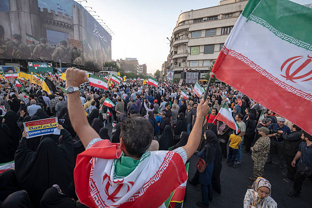 Un Iranien avec le drapeau national célèbre le cessez-le-feu après 12 jours de guerre à Téhéran, le 24 juin 2025. (Photo de Morteza Nikoubazl/NurPhoto via Getty Images)
